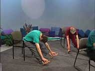 two people sitting in chairs bend forward